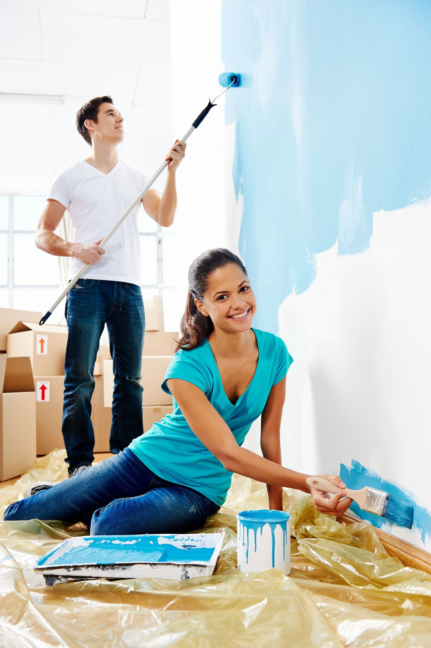 photo of a young couple painting their new home